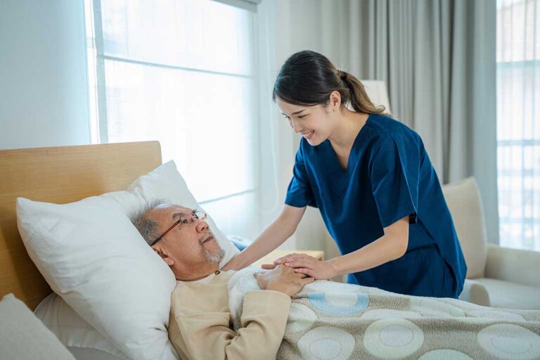A family visiting an older adult in a cheerful assisted living community common room.